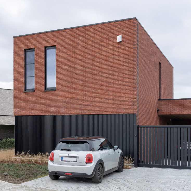 Moderne woning met rood genuanceerde gevelsteen en aluminium gevelbekleding (type Alinel)